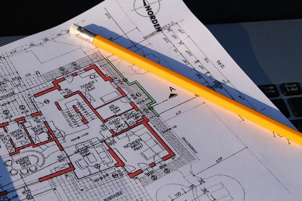 Ein Bauplan ist zu sehen, auf dem ein gelber Bleistift liegt.