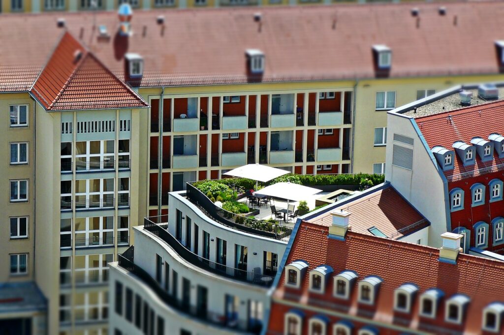 Mehrere Wohnhäuser sind zu sehen, davon eines mit einem Flachdach, auf dem eine Dachterrasse gebaut wurde.